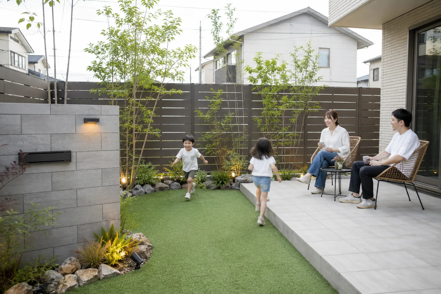 人工芝とタイルテラスで家族が過ごす新築の庭