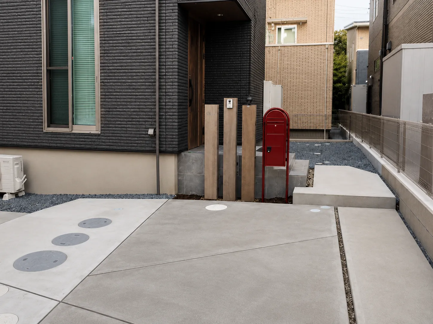 印西市の外構施工事例。ボルドー色のボビカーゴポストとスリーパー門柱、玄関アプローチを撮影。